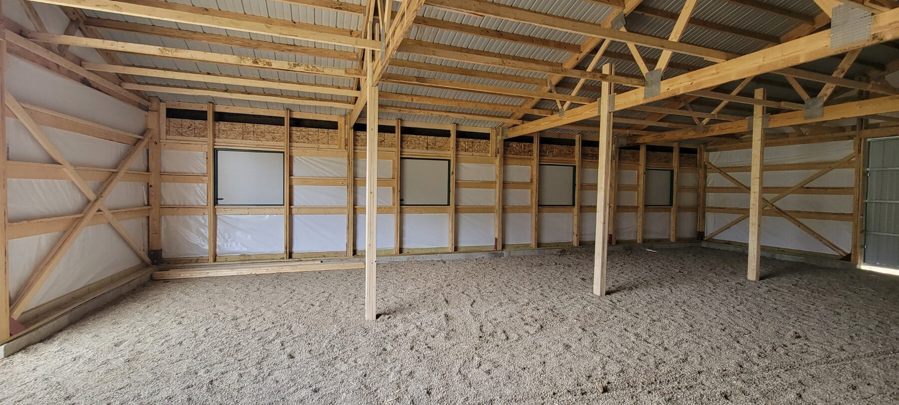 Interior of a completed post-frame building with timber framing